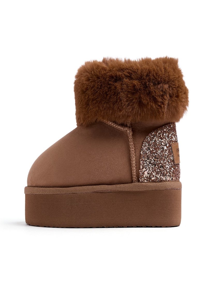 Botas de tobillo de ante sintético marrón con un cuello de piel sintética marrón esponjoso, un acento de brillo texturizado en la parte trasera y una suela de goma plana.