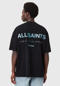 Juodas per didelis T-shirt, ant kurio raudona, kontrastinga šviesiai mėlyna spalva „ALLSAINTS“, su japoniškais simboliais ir žodžiu „LONDON“ po jais. Minkšta medvilnė.
