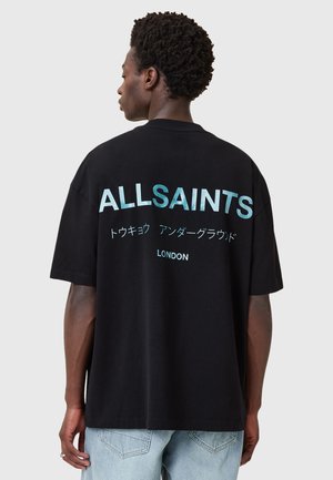 Ylipitkä musta T-paita, jossa on kontrastivärinen vaaleansininen teksti "ALLSAINTS" ja japaninkielisiä merkkejä, sekä "LONDON" alla. Pehmeä puuvillamateriaali.