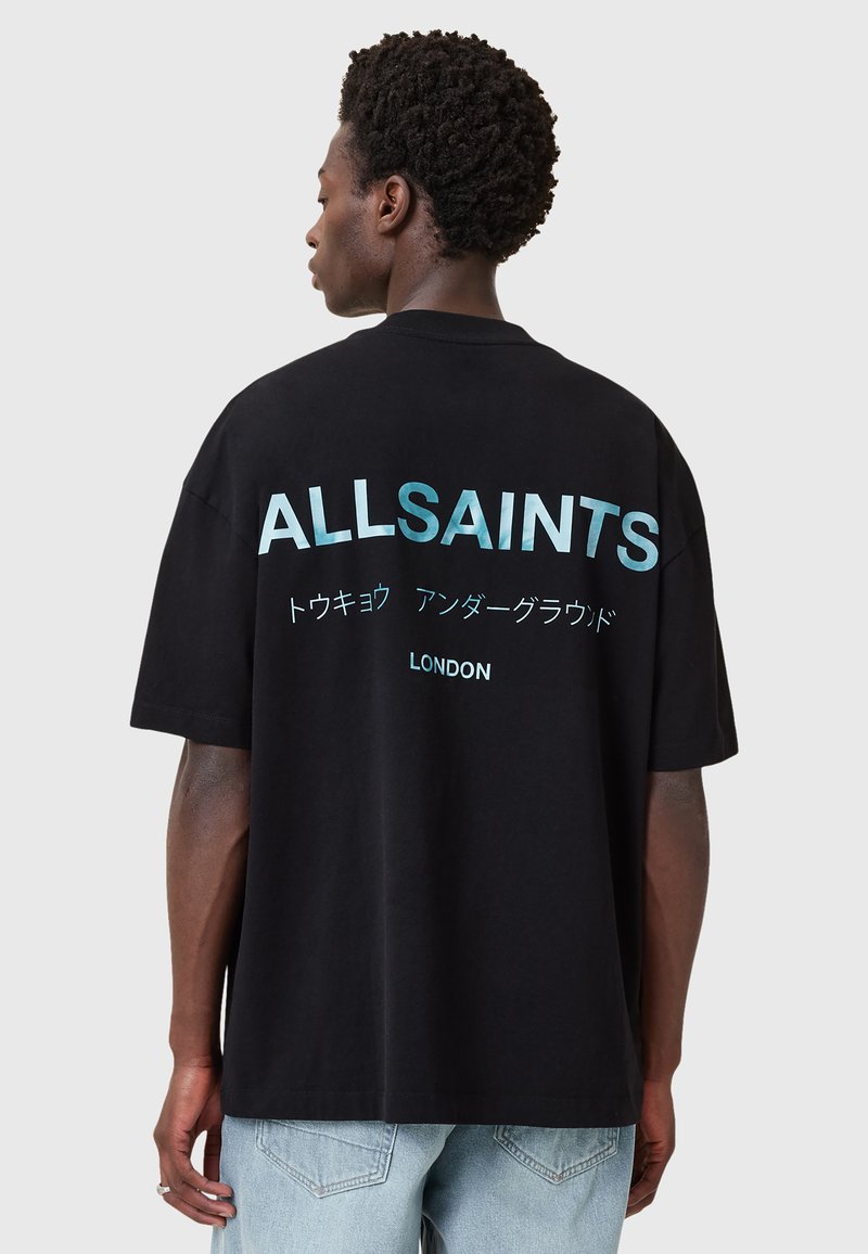 Juodas per didelis T-shirt, ant kurio raudona, kontrastinga šviesiai mėlyna spalva „ALLSAINTS“, su japoniškais simboliais ir žodžiu „LONDON“ po jais. Minkšta medvilnė.