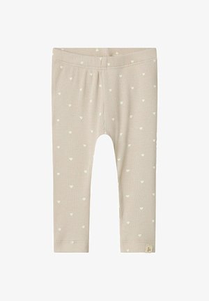 Leggings beige a coste con piccoli motivi a cuore bianchi. Vita elastica e design a gamba dritta, con un'etichetta brandizzata all'orlo.