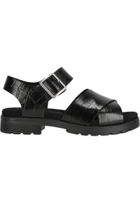 Svart sandal med en texturerad, krokodilpräglad yta, justerbar ankle strap med en silverfärgad spänne, och en kraftig, texturerad sula.