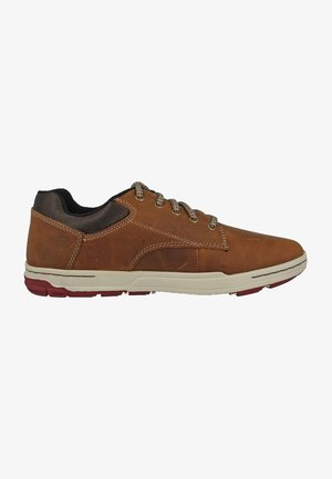 Zapatilla de cuero marrón con suela de goma beige, que cuenta con cordones grises y un cuello de tela marrón texturizada. La vista lateral muestra un diseño minimalista.