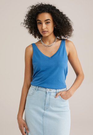 Blue sleeveless top with a V-neck and fitted design. Paired with a light denim skirt, showcasing a casual aesthetic. Silver chain necklace accent.