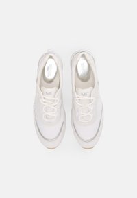 Scarpe da tennis bianche con una tomaia in rete liscia, design con lacci e dettagli in argento. La suola è leggermente texturizzata con una tonalità beige.