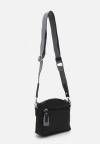 Černá krossbody taška se zipovým uzávěrem, malou přední kapsou a nastavitelným páskem se vzorem. Disponuje stříbrnými detaily a texturovaným povrchem.