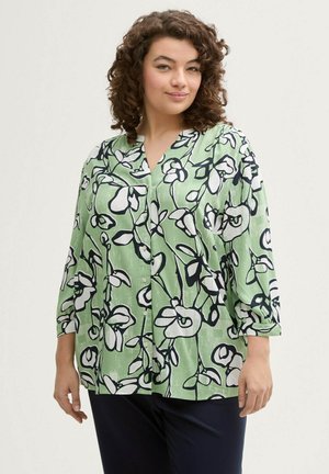 Blusa verde con estampado floral en blanco y negro, con botones en la parte delantera y mangas de tres cuartos. Tejido suave con textura ligera.