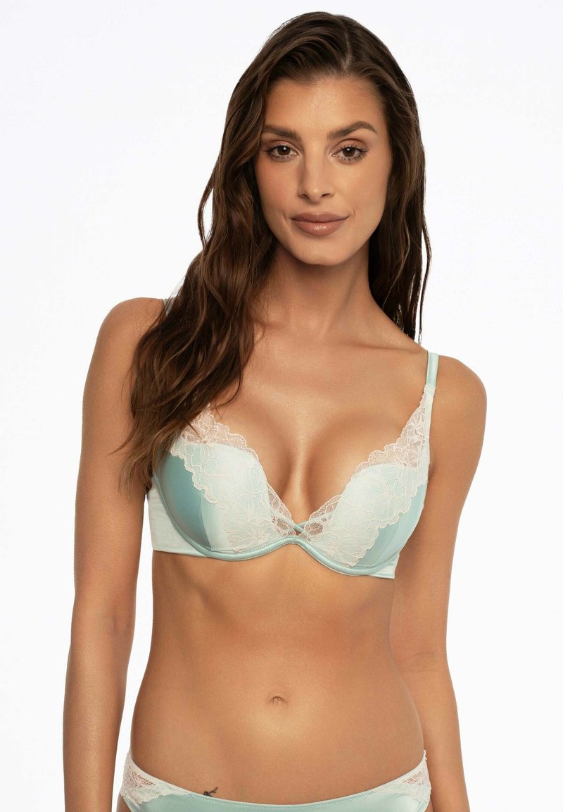 Jasnoniebieski biustonosz z koronkowym wykończeniem, głębokim dekoltem i regulowanymi ramiączkami. Gładki materiał i koronkowe akcenty dodają faktury i detali.