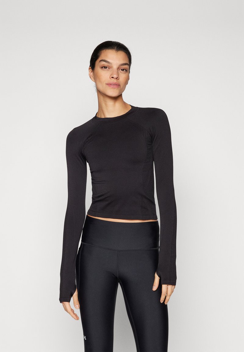 Svart långärmad åtsittande topp med rund halsringning och tumhål, tillsammans med högmidjade svarta leggings. Slät, elastisk tyg.