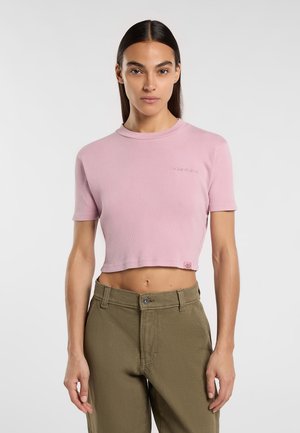 T-shirt cropped a coste color rosa chiaro con scollatura tonda e maniche corte, dotato di un piccolo logo ricamato e un'etichetta sull'orlo.