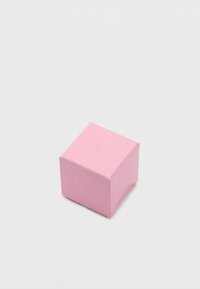 Απαλό ροζ κύβος με υφή επιφάνειας, τοποθετημένος σε απλό λευκό φόντο.