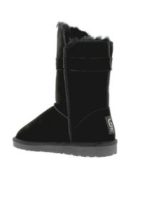Black suede ankle boot with a soft fur lining, featuring a flat rubber sole and a side strap detail. Logo accent on the heel.