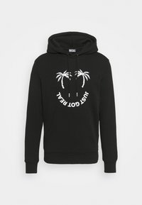 Black hooded sweatshirt made of cotton, featuring a front kangaroo pocket, white palm tree graphic, and circular text saying "JUST GOT REAL."