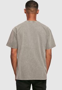 Gray oversized t-shirt made of soft cotton, featuring short sleeves and a round neckline, with a slightly faded texture.