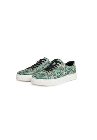Sneakers with a tropical print featuring greenery and birds, black laces, white soles, and textured fabric. Rounded toe and minimalistic design.