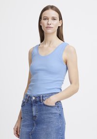 Sinine ribaga triiksärgi top laiemate rihmadega, keha ligi, kombineeritud kõrge talje denim seelikuga. Kerge, sile tekstuur.