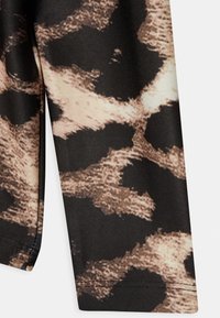 Leggings com padrões de leopardo que apresentam uma combinação de tonalidades preta, castanha e bege, confeccionadas em tecido liso e elástico com uma textura suave.