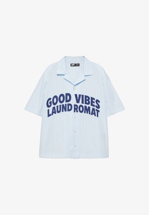 Camicia a righe azzurro chiaro e bianco a maniche corte con bottoni e testo blu scuro che recita ""GOOD VIBES LAUNDROMAT"" sul davanti.