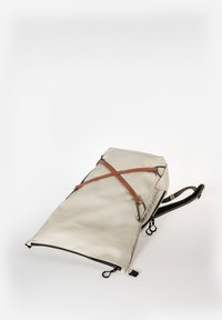 Beiger Rucksack aus strapazierfähigem Stoff, mit braunen Lederträgern, einem Reißverschluss und einem schrägen Design für ein elegantes Erscheinungsbild.