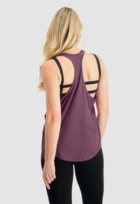 Lila Tanktop mit abgerundetem Saum, dünnen schwarzen Trägern und einem Rückendesign mit horizontalen Ausschnitten. Glatte Textur.