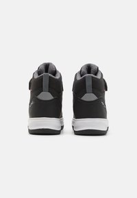 Sneakers neri alta top con una parte superiore in pelle e tessuto liscia, un colletto imbottito grigio e una suola in gomma bianca con accenti grigi.