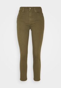 Jeans skinnies de color verde olivo con cintura alta, que presentan un cierre frontal con botón y cremallera, pasadores para cinturón y un diseño estándar de cinco bolsillos.