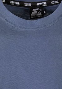 Blue short-sleeve t-shirt made of soft fabric with a round neckline. Features a "Starter Black Label" tag and smooth texture.