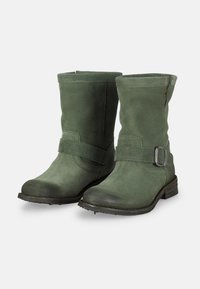Botas de ante verde hasta el tobillo con puntera redondeada, altura a media pantorrilla, hebilla decorativa en el costado y acabado texturizado. Tacón pequeño y suela de goma.