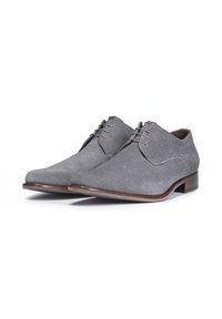 Graue Stoffschuhe mit glatter Textur, spitzer Zehenpartie und braunen Lederakzenten. Mit Schnürverschluss und flachem Absatz.