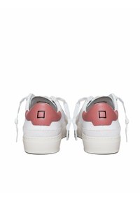 Sneakers bianchi con accenti rosa, tacco rotondo, finitura texturizzata e lacci piatti. Parte posteriore con un logo quadrato su una superficie liscia.
