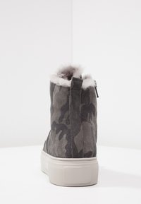 Stivaletto in suede grigio con motivo camouflage, dotato di una suola in gomma bianca e un morbido rivestimento in pelliccia grigia sul colletto.