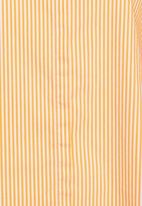 Vertical white and orange striped fabric with visible seam and stitching down the center.