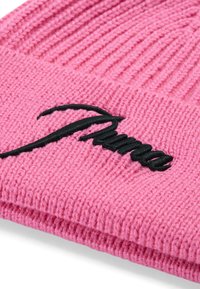 Roze breipet met een geribbelde textuur en een zwart geborduurd "Puma" logo aan de voorkant. Zacht materiaal, met omgeslagen ontwerp voor extra warmte.