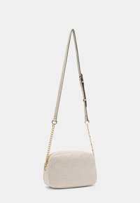 Krémová crossbody taška s diamantovým vzorem embosovaným na kůži, se hladkým povrchem, zlatými řetězy a nastavitelným popruhem.