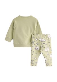 Vaaleanvihreä puuvillapaita, jossa on joustavat hihansuut, yhdistettynä elastisiin legginsseihin, joissa on leikkisiä eläin- ja luontoaiheisia kuvioita.