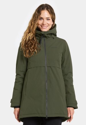 Olijfgroene waterdichte jas met een hoge kraag, ritssluiting aan de voorkant, verstelbare capuchon en een relaxte pasvorm. Heeft lange mouwen en een klepzak.