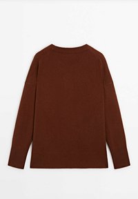 Pull en tricot marron avec une coupe ample, un col rond et des manches raglan. Texture lisse et poignets et ourlet côtelés. Coutures claires visibles.