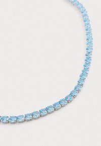 Colar de pedra preciosa azul com pedras redondas e facetadas, montadas em metal prateado, dispostas em uma linha curva.