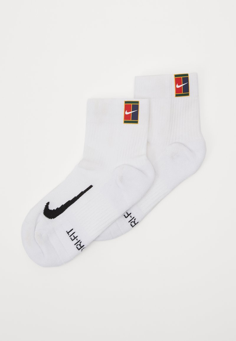 Fehér sportzokni, fekete Nike logóval és színes, téglalap alakú címkével, rajta a Nike logóval.