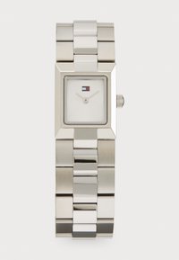 Silver stainless steel watch with a square face, white dial, thin hands, and a small logo at 12 o'clock. Link bracelet design.