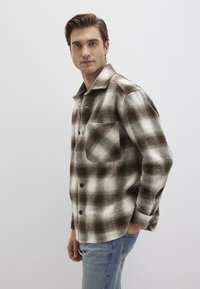 Grünes und weißes karierte Flanellhemd mit einer Brusttasche, knopfigem Frontverschluss und bequemer Passform. Leger gewebter Stoff mit einer weichen Textur.