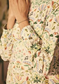 Camicia in tessuto leggero con motivo floreale, decorata con animali in stile cartone animato nei colori rosa, verde, giallo e bianco. Maniche lunghe con dettagli ai polsini.