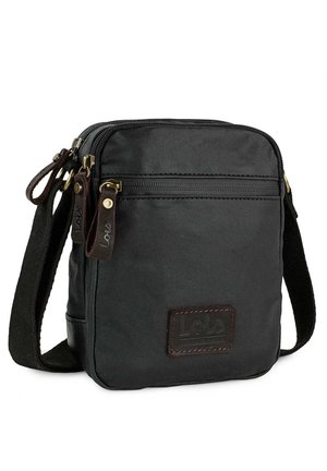 Bolso cruzado de lienzo negro con detalles en cuero marrón, compartimento principal con cremallera, bolsillo frontal y correa ajustable. Etiqueta de la marca visible en el frente.