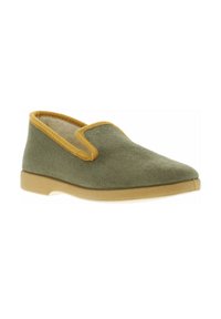 Chaussure slip-on en suède vert avec une semelle en caoutchouc beige et un liseré jaune le long de l'ouverture. Texture lisse et design à bout rond.