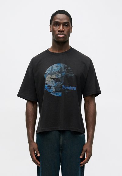 Black oversized t-shirt features a circular blue graphic and the text "Hundred" in blue. Cotton material with a smooth texture.
