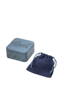 Metalen blauwe vierkante tin met "Fossil" lettering, gedetailleerd met illustraties. Vergezeld van een marineblauwe trekkoordzak met logo.