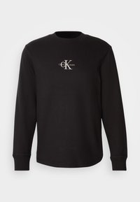 Fekete, hosszú ujjú pulóver strukturált anyagból, kerek nyakkivágással és fehér "CalvinK Jeans" logóval a mellrészen.
