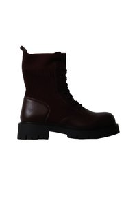 Botte de combat marron foncé à lacets avec semelle épaisse noire et partie cheville en tissu côtelé, vue de côté sur fond blanc.