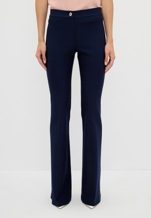 Navy flarebroek van een soepele stof met een platte tailleband en een gouden knoopdetail. Gestructureerde pasvorm met een lichte stretch.