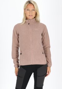 Polarowa kurtka w jasnoróżowym kolorze z pełnym suwakiem z przodu, dwoma kieszeniami bocznymi na zamek i wysokim kołnierzem. Teksturowany materiał i dopasowany krój.